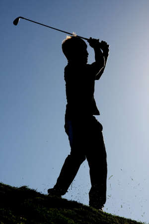 Silhouette of a golf player on the fairwayの写真素材