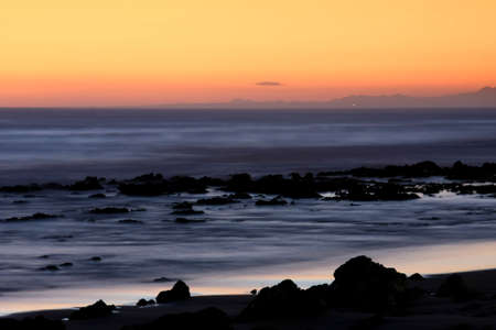 Beautiful sunset at the coast with rocks in the foreground
