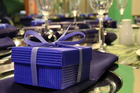 Table setting with blue present box and ribbonの写真素材