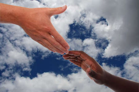 Caucasian hand reaching out to an African hand in help