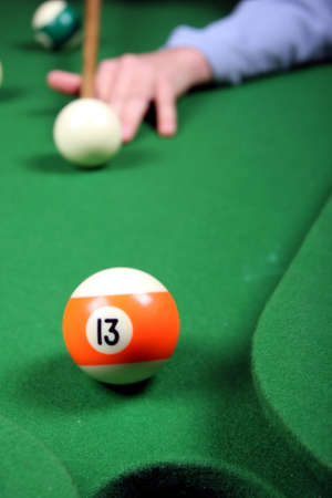 Number 13 ball about to be sunk on the pool table