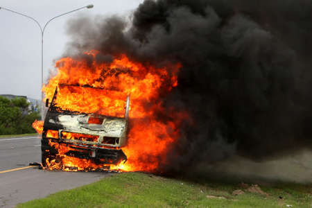 Delivery vehicle ablaze on the side of the road way