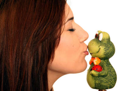 Pretty brunette girl kissing a toy frogの写真素材