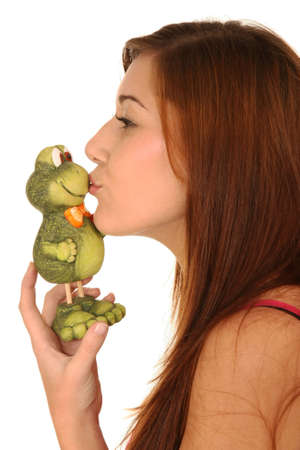 Pretty brunette girl kissing a toy frogの写真素材
