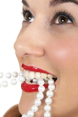 Face of pretty woman with string of pearls in her mouthの写真素材
