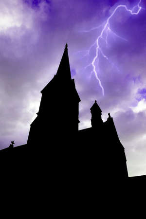 Old silhouetted building with towers and lightning in the backgroundの写真素材
