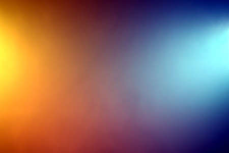 Background of orange and blue color lights shining through fogの写真素材