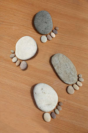 Smooth beach stones arranged to look like foot printsの写真素材