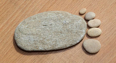 Smooth beach stones arranged to look like foot printの写真素材