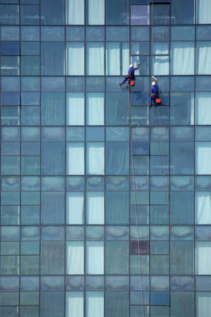Two window cleaner men high up on the outside of a buildingの写真素材