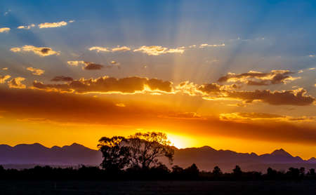 A beautiful golden sunset with mountains in the backgroundの写真素材