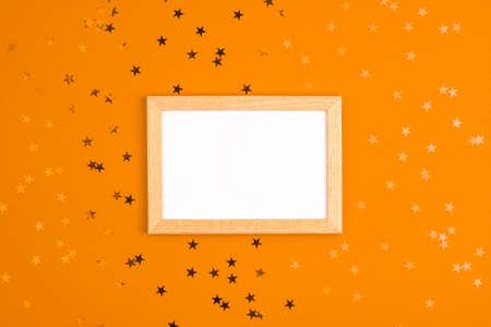 Mockup white frame and stars around on vibrant orange background. Mothers day holiday presents happy birthday concept with space for your text template flat layの写真素材