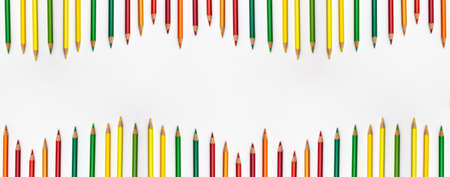 Banner of pencils different colors fro red to green o the top and bottom flat lay top view on white background with copy space.  Education banner back to school online study concept copy spaceの写真素材
