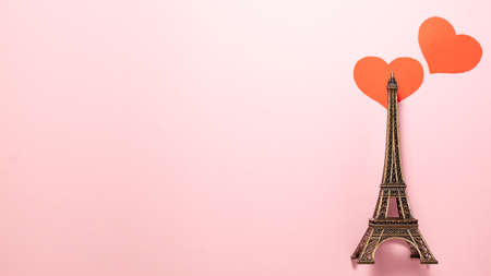 The Eiffel Tower, two red on pink background at the right side of the frame. Flat lay top view...