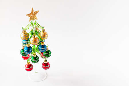 Christmas concept. Red, green, blue and gold balls decorate the decorative xmas tree with star on...