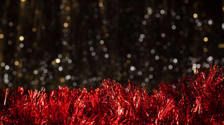 Christmas dark background with silver and gold colors bokeh and red decoration at the battom. Holiday concept with copy spaceの写真素材