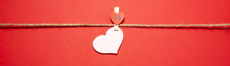 Banner of tweezer for clothes hold the pink heart on red background. Valentines day concept. Flat...