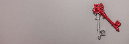 Red and silver vintage keys with glitter interpret clock hands on gray background on the right side. Flat lay top viewの写真素材