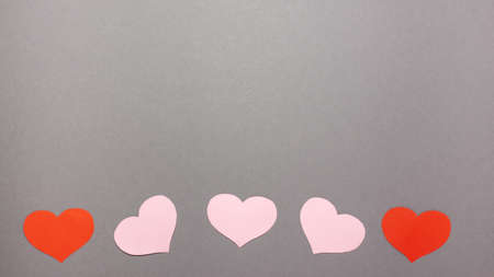 Red and pink hearts on gray background at the bottom. Valentines day concept. Flat lay top view with copy space.の写真素材