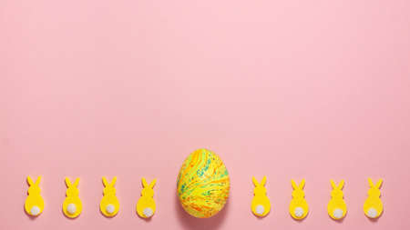 Yellow velvet bunnies and easter egg on pink background at the bottom with copy space. Flat lay top view. Easter conceptの写真素材