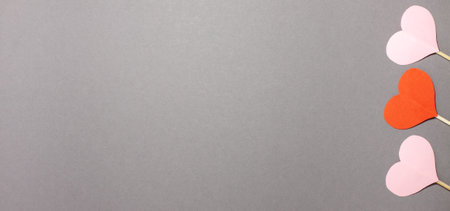 Red and pink hearts banner on gray background at the right side. Valentines day and emotion concept. Flat lay top view with copy space.の写真素材