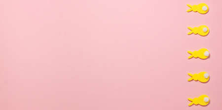 Banner of yellow velvet bunnies on pink background on the right side with copy space. Flat lay top view. Easter concept.の写真素材