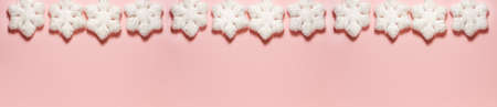 Banner of white snowflakes with glitter on a bright pink background at the top. Christmas concept lay lay top view with copy spaceの写真素材