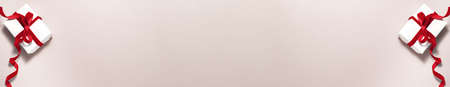 Banner of gift white paper box with a red ribbon bow on beige background with copy space. Flat lay top view Christmas winter holidays Valentine's day anniversary surprise and xmas presents conceptの写真素材