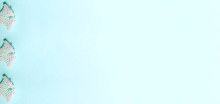 Banner of bright pink glossy glitter jingle bells on blue background on the left side. Flat lay New Year and Christmas holidays concept with copy spaceの写真素材