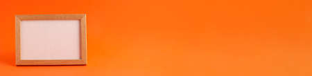 Close up banner of mockup template white frame with wooden borders on orange blurred background and copy space. Holiday autumn concept backdropの写真素材