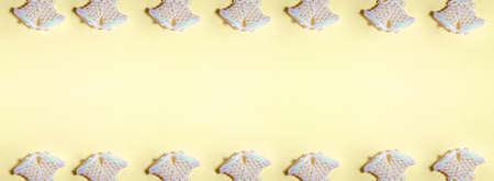 Banner of bright blue glossy glitter jingle bells on yellow background on the left side. Flat lay New Year and Christmas holidays concept with copy spaceの写真素材