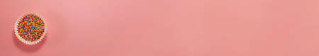 Banner of cupcake liners with colored sugar inside from above. Flat lay top view. Confectionery...