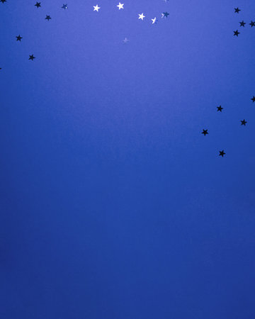 Dark blue stars shapes at the top on blue background. Christmas winter holiday concept flat lay top view with copy spaceの写真素材