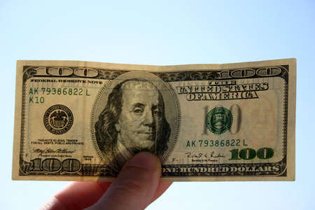 Checking 100 dollars banknote. In background of sky. Transparent, can see watermarks