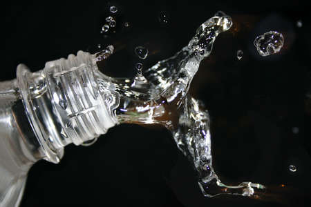 Water splash - bottle and water drops in a moment.の写真素材