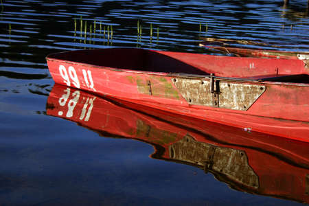 High coloured boat and reflection on the waterの写真素材