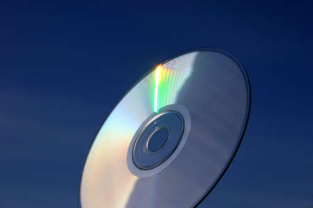 Compact disc close-up against the sky backgroundの写真素材