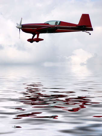 Airplane over the water, reflectionの写真素材