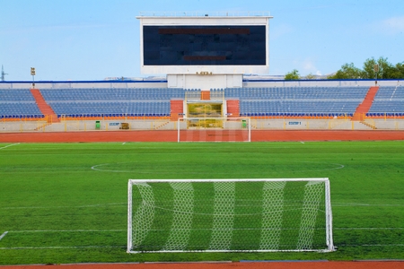 Football field with goal and tablo on blue skyの写真素材