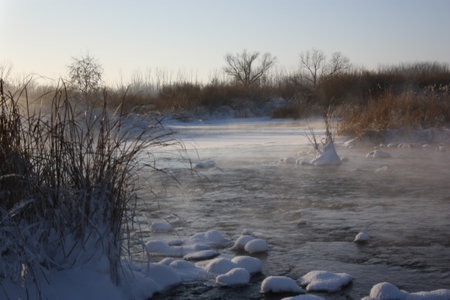 Winter river in snow landscape. Frozen river water in winter