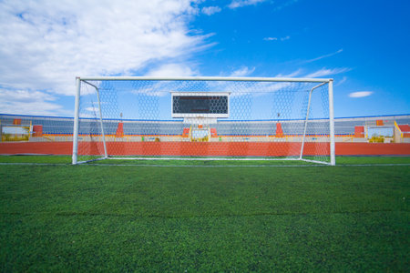 Football field with goal and tablo on blue skyの写真素材