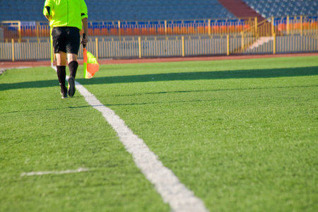 Football field with goal and tablo on blue sky