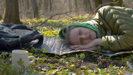 Close up portrait of young tired sleepy woman in the forest after lunch. Early spring, sunny...