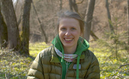 Portrait of cheerful and happy woman sitting in the forest. She smiling and laughing. Early spring, sunny weather. Healthy lifestyle conceptの写真素材
