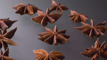 Macro shot of dried star anise - famous aromatic spice - on the gray glass background