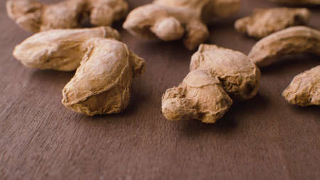 Macro shot of dried ginger roots - famous aromatic spice on the wooden table. Extreme close upの写真素材