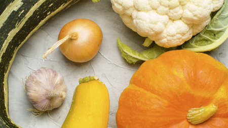 Close up ripe fresh raw vegetables - pumpkin, onions, zucchini, cauliflower - on white background. Top viewの写真素材