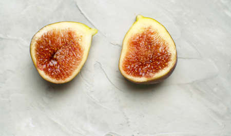 Macro shot halves of ripe fig on the table on white background. Healthy fresh food conceptの写真素材