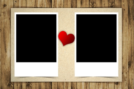 Blank photo and red heart isolated on wooden backgroundの写真素材