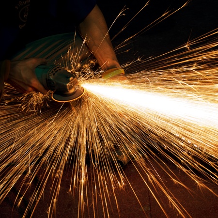 Worker making sparks while welding steel の写真素材
